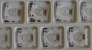 top row of scissor mechanisms are inserted under the flap; bottom row of scissor mechanisms are both under the flap and in the holes